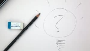 Pencil and eraser with a hand drawn lightbulb and question mark