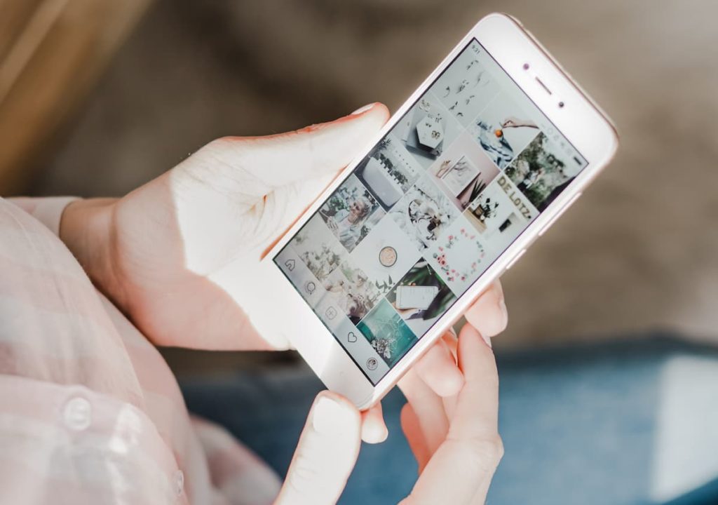 Person looking at their mobile phone Instagram page feed