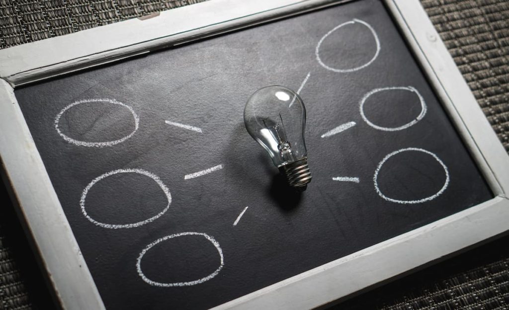 Clear lightbulb on blackboard with chalk