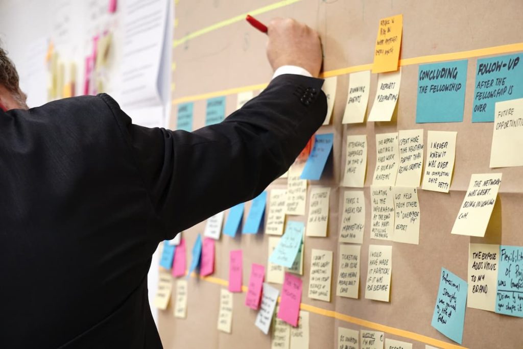 Man writing on post-it notes on the wall